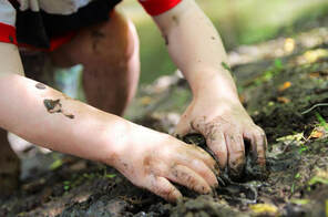 muddy toddler hands digging in soil